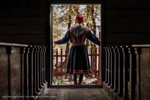 saamenpukuinen nainen kirkon ovella